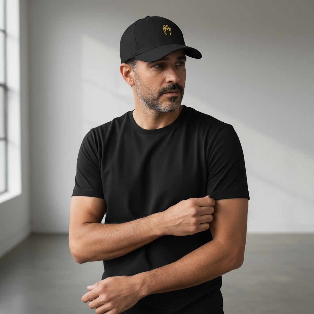 The Savage Mammoth black structured 6-panel cap with yellow hand embroidery worn by a man in a black t-shirt