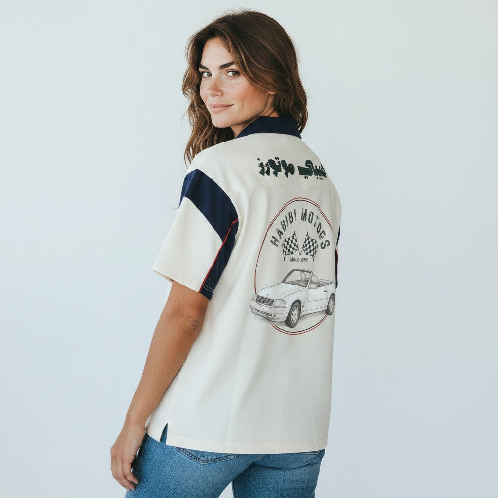 The Savage Mammoth unisex boxy polo shirt in white and navy with a vintage car graphic and Arabic script on the back